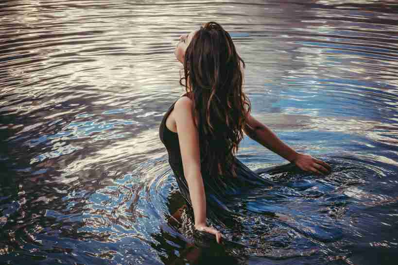 Girl model in black wet in pond