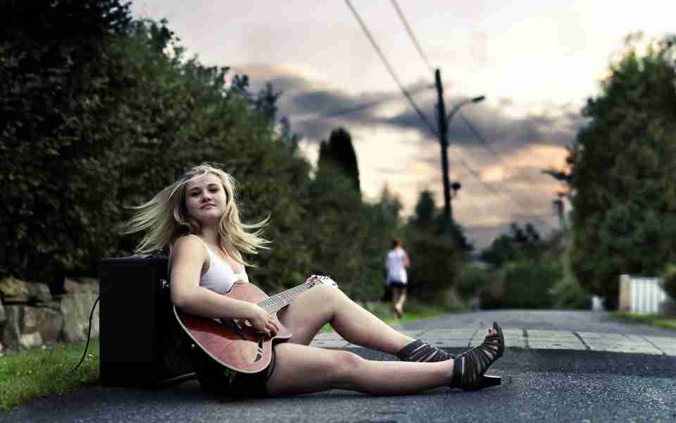 Girl playing guitar on street